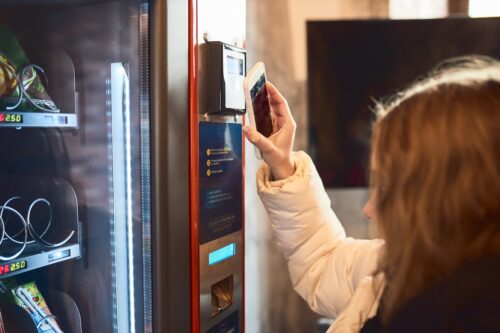 woman paying for food at vending machine